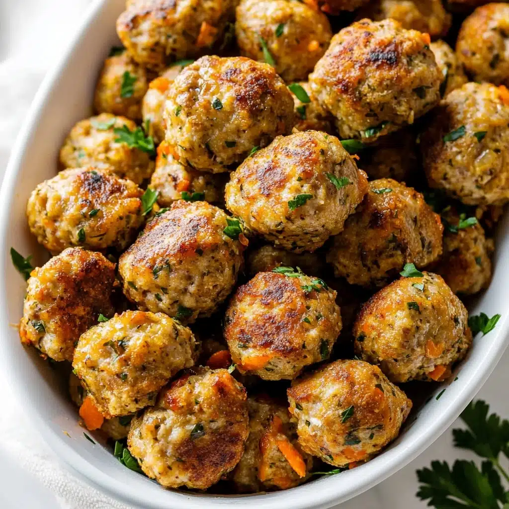 Turkey Stuffing Balls, Thanksgiving leftovers snacks, savory stuffing bites, holiday appetizer ideas, easy turkey ball recipe The image shows a white bowl filled with many small round meatballs that have a golden brown color with crispy spots. Each meatball has visible bits of herbs and small colored pieces inside them, giving a textured look. There are some small green parsley leaves sprinkled on top and a larger parsley leaf resting inside the bowl, adding a fresh touch. The bowl is placed on a white marbled surface with a soft, gray cloth partially visible under the bowl. The lighting highlights the shiny and slightly oily surface of the meatballs, making them look warm and appetizing.