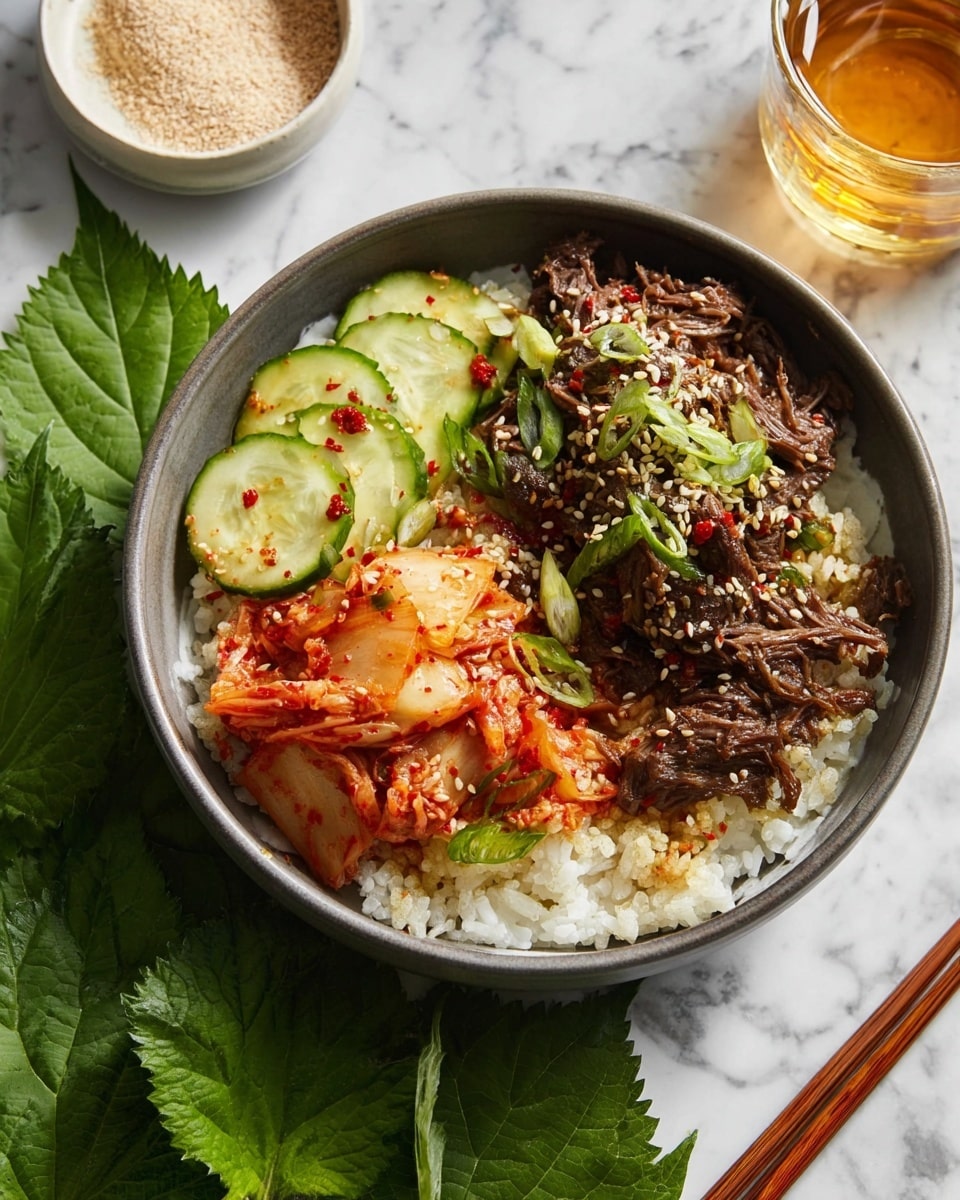 A dark gray bowl on a white marbled surface holds a meal with three main parts. The base layer is white rice, soft and slightly sticky. On one side of the rice are thin, pale green cucumber slices with some red chili flakes on top. Next to the cucumber is a small pile of bright red-orange kimchi with a wet, slightly wrinkled texture. Covering almost half of the bowl, on top of the rice, is tender shredded brown beef garnished with toasted sesame seeds and thin, bright green slices of scallion. The bowl is placed on a matching dark gray plate. In the background, there is a clear glass filled with pale yellow liquid and a small white bowl with toasted sesame seeds next to a pair of brown chopsticks. Photo taken with an iphone --ar 4:5 --v 7