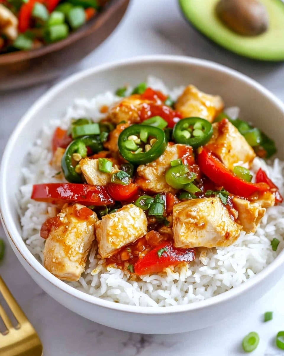 The dish shows a white bowl filled with a base layer of fluffy white rice, topped with pieces of golden-brown cooked chicken, sliced green jalapeño peppers, and sliced red bell peppers. Bright red sauce is drizzled over the chicken and vegetables, and small green slices of scallions are scattered on top. In the background, a wooden bowl with more chopped green onions can be seen along with a green avocado half and a golden fork placed on a white marbled surface. photo taken with an iphone --ar 4:5 --v 6.1