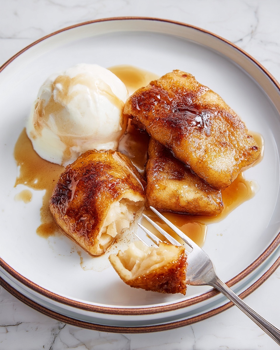 Crescent Apple Dumplings: Cozy Fall Deliciousness 1 The plate shows three pieces of golden-brown fried dessert with a crispy, slightly shiny texture, layered closely on the right side. On the left side, there is one scoop of smooth, white ice cream with a light drizzle of brown sauce running down its side. A silver fork holds a piece of the fried dessert at the bottom of the plate, showing the inside, which looks soft and light yellow. The plate is white with a thin brown rim, set on a white marbled surface. photo taken with an iphone --ar 4:5 --v 7