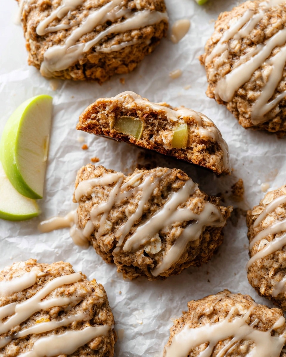 The image shows a white plate with a scalloped edge holding eight round oatmeal cookies. The cookies have a rough, chunky texture with visible oats and are golden-brown in color. Each cookie has a drizzled light beige glaze, unevenly spread over the top. The plate is set on a white marbled surface, with a green cloth napkin partially visible at the bottom left corner. On the upper left side, there is a beige ceramic cup filled with a light brown drink, likely coffee or tea. photo taken with an iphone --ar 4:5 --v 7
