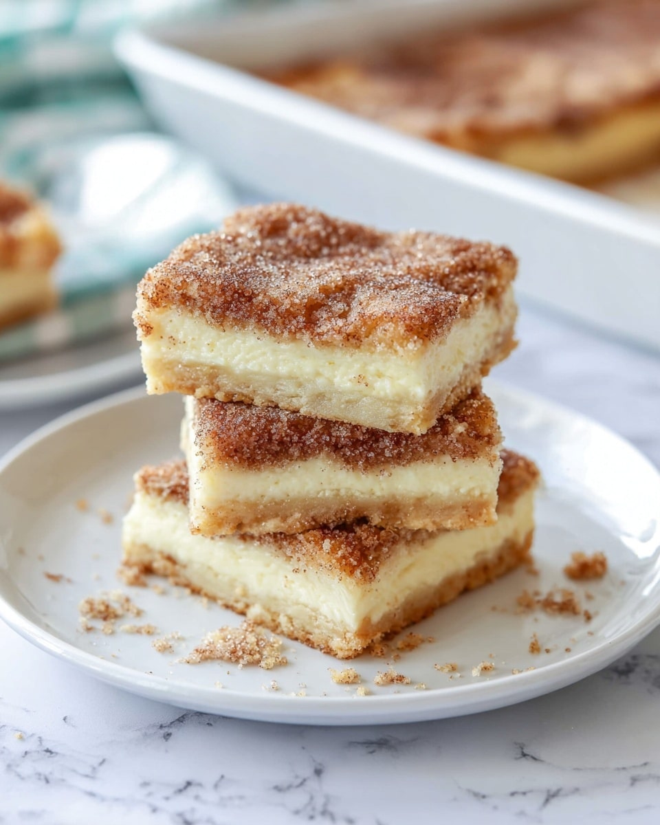 A stack of three square dessert bars sits on a white plate with a soft white marbled texture surface underneath. Each bar has three visible layers: a bottom golden-brown crust, a thick creamy white middle layer, and a top layer dusted with a rough, crumbly mix of cinnamon and sugar in warm brown tones. The edges of the bars are slightly uneven, showing the soft texture inside. There are crumbs scattered lightly around the plate, enhancing the homemade feel. The scene is bright and clear, emphasizing the soft texture and warm colors of the bars. Photo taken with an iphone --ar 4:5 --v 7
