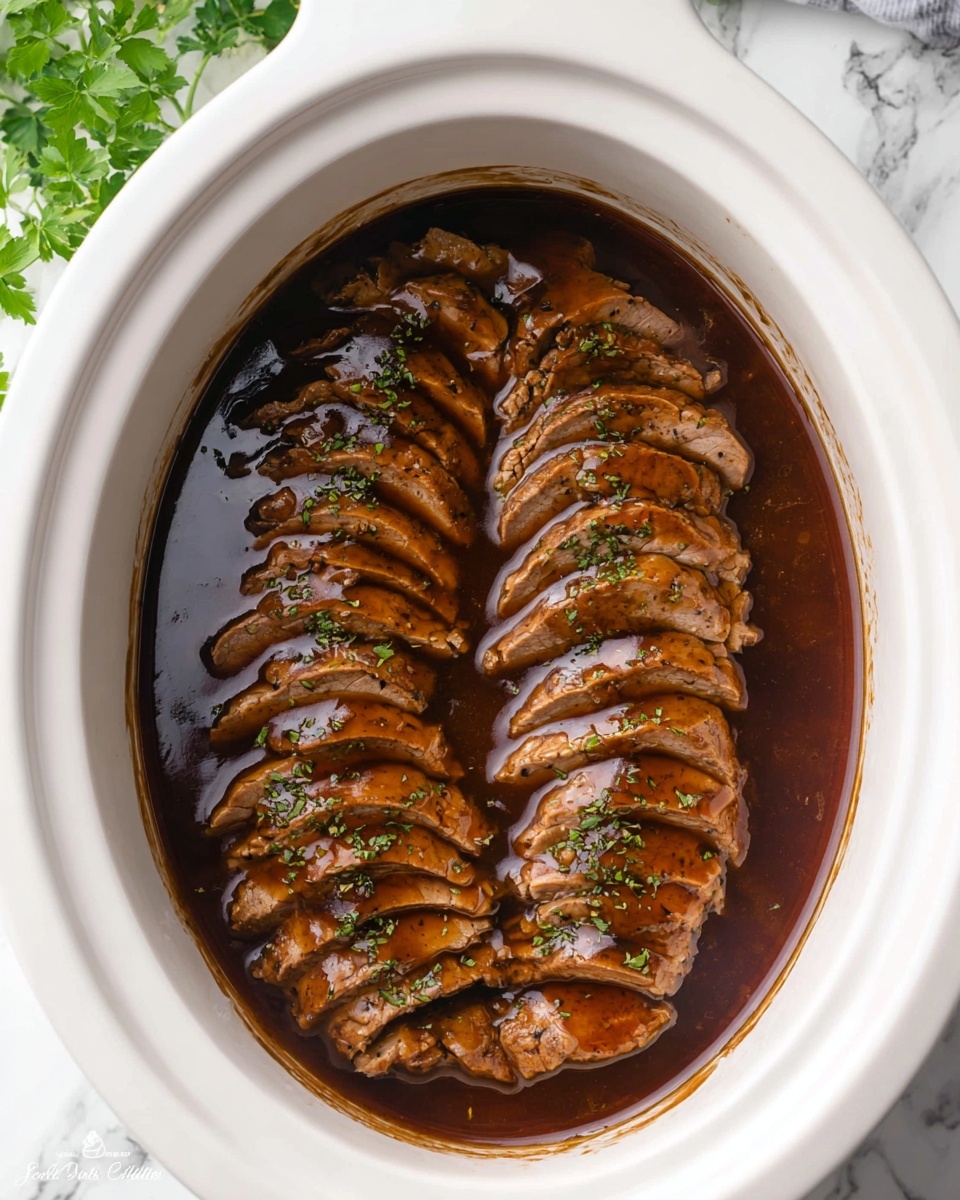 Two rows of sliced cooked meat are placed inside a white slow cooker, each piece covered with a shiny dark brown gravy. The meat slices are arranged in neat layers, slightly overlapping, showing a tender texture with small bits of green herbs sprinkled on top. The gravy pools around the meat, filling the bottom of the cooker and creating a glossy effect. The slow cooker sits on a white marbled surface with green leaves slightly visible in the top left corner, adding a touch of color. Photo taken with an iphone --ar 4:5 --v 7
