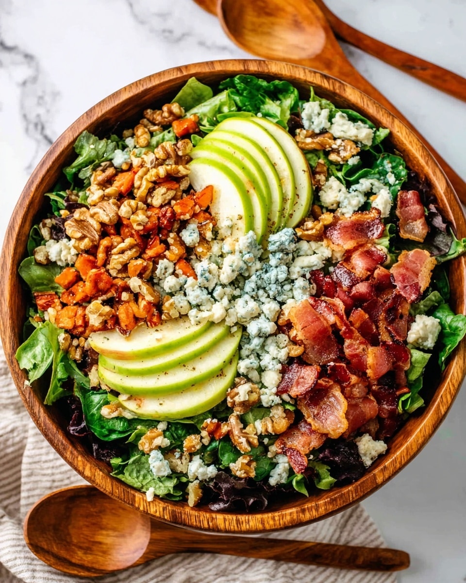 A wooden bowl filled with a fresh salad sits on a white marbled surface. The salad has a base layer of mixed green leafy vegetables. On top, there are four groups of toppings arranged in a circle: sliced green apples with thin, bright green layers on the right and bottom, clusters of golden brown walnuts mixed with dark raisins in the top and center, small chunks of blue cheese strewed over the salad, and crispy bacon pieces with reddish-brown colors on the left and right edges. Two wooden spoons rest on the white marbled surface beside the bowl with part of a blue cloth visible in the upper left corner. Photo taken with an iphone --ar 4:5 --v 7