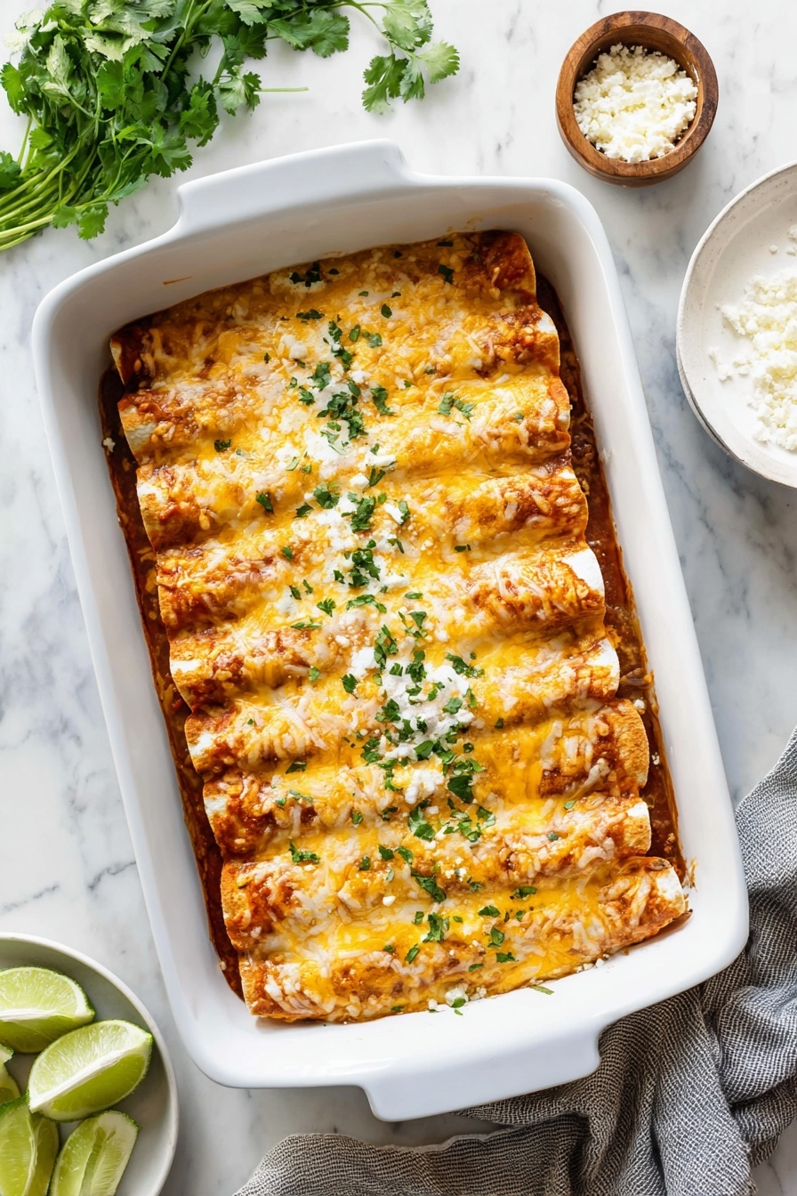 Cheesy Chicken Enchiladas Recipe 2 A white baking dish filled with seven evenly spaced rolled enchiladas covered in melted cheese that is golden and slightly browned. The cheese layer is smooth and glossy with a few spots of orange from melted cheddar, topped with small chopped green herbs scattered over the entire dish. The enchiladas have a soft, slightly textured surface visible under the cheese. The dish sits on a white marbled surface with a soft natural light highlighting the warm colors of the food photo taken with an iphone --ar 4:5 --v 7