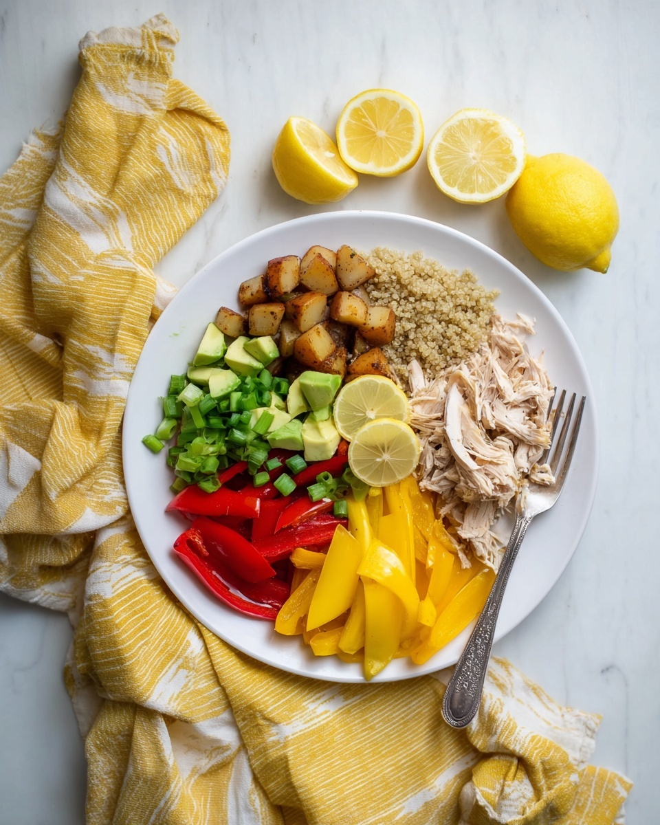 A white plate has seven sections of food arranged in a circle on a white marbled surface. Starting from the top and moving clockwise, there are light green chopped scallions, shredded pale beige cooked chicken, small brown roasted potato pieces, thin red bell pepper strips, thin yellow bell pepper strips, light beige quinoa, and sliced bright green avocado. In the center of the plate, there are two lemon wedges showing yellow flesh. A silver fork is resting on the right side of the plate over the roasted potatoes and bell peppers. Around the plate are three lemon halves and a white towel with yellow stripes. Photo taken with an iphone --ar 4:5 --v 7