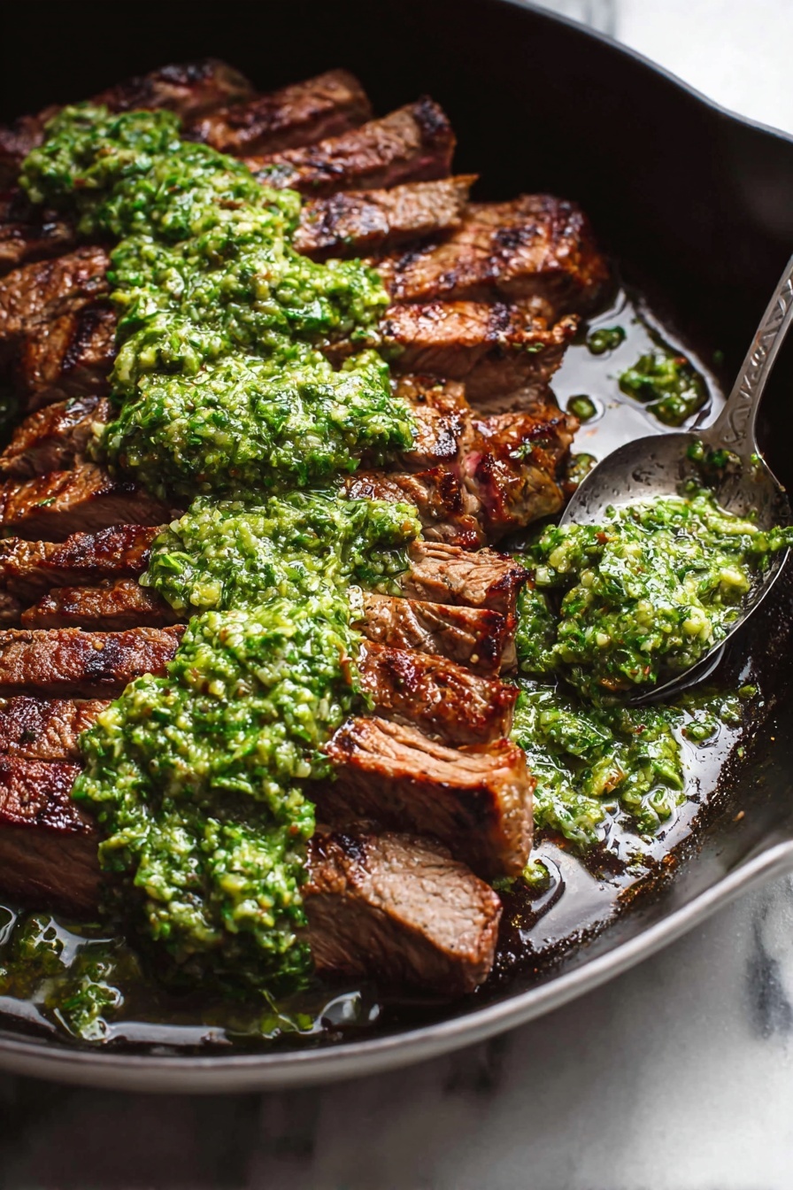 The image shows a dark pan filled with sliced grilled steak arranged in a semi-fan shape, with each slice showing a rich brown grilled texture and visible sear marks. On top, there is a thick layer of bright green sauce with a chunky texture spread unevenly across the steak. Green sauce drips down some parts and pools slightly in the pan, reflecting light and showing a mix of herbs and oil. A spoonful of the green sauce sits at the edge of the pan. The pan rests on a white marbled surface. photo taken with an iphone --ar 4:5 --v 7