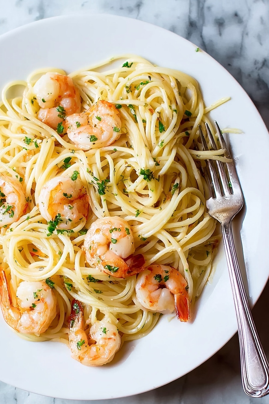 A white plate holds a serving of spaghetti pasta, which forms the base layer with its pale yellow color and smooth texture. On top, there are several cooked shrimp arranged around the plate, each shrimp showing an orange and pink color with white meat inside. Small chopped green herbs are sprinkled over the pasta and shrimp, adding touches of green throughout. A silver fork rests on the right side of the plate, touching the pasta. The plate sits on a white marbled surface. photo taken with an iphone --ar 4:5 --v 7