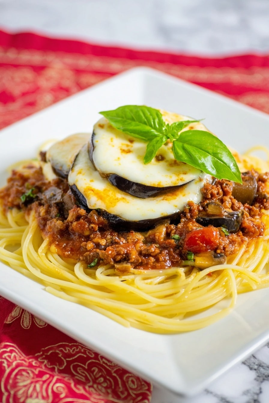 Caramelized Garlic and Onion Spaghetti Sauce Recipe 5 Four fried eggplant slices are placed on a white plate with blue floral patterns; each slice is coated in golden brown breadcrumbs with a melted layer of light golden cheese on top, slightly bubbling and browned at the edges. Behind the plate is a small white bowl filled with grated cheese, and to the right a silver fork rests beside a folded yellow and white checked napkin, all set on a white marbled surface. Photo taken with an iphone --ar 4:5 --v 7