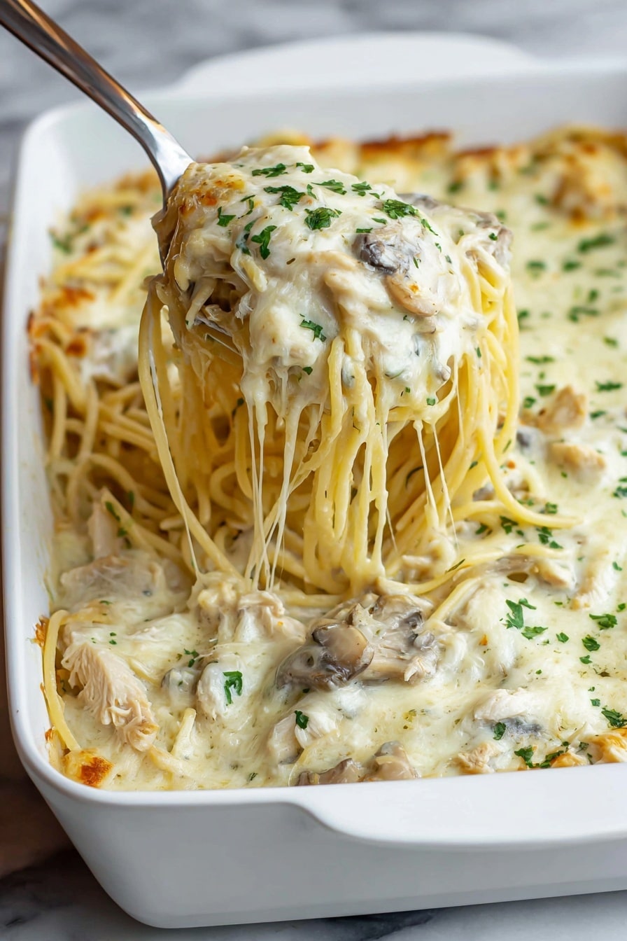 A white rectangular ceramic dish on a brown wooden surface holds a baked creamy pasta casserole with visible layers: the bottom layer is spaghetti noodles mingled with pieces of meat, topped by a thick, smooth white cheese sauce covering the entire dish, sprinkled evenly with finely chopped green herbs, likely parsley, adding a fresh pop of color against the soft white cheese. The edges of the casserole show hints of lightly browned cheese and noodles peeking through the sauce. Photo taken with an iphone --ar 4:5 --v 7