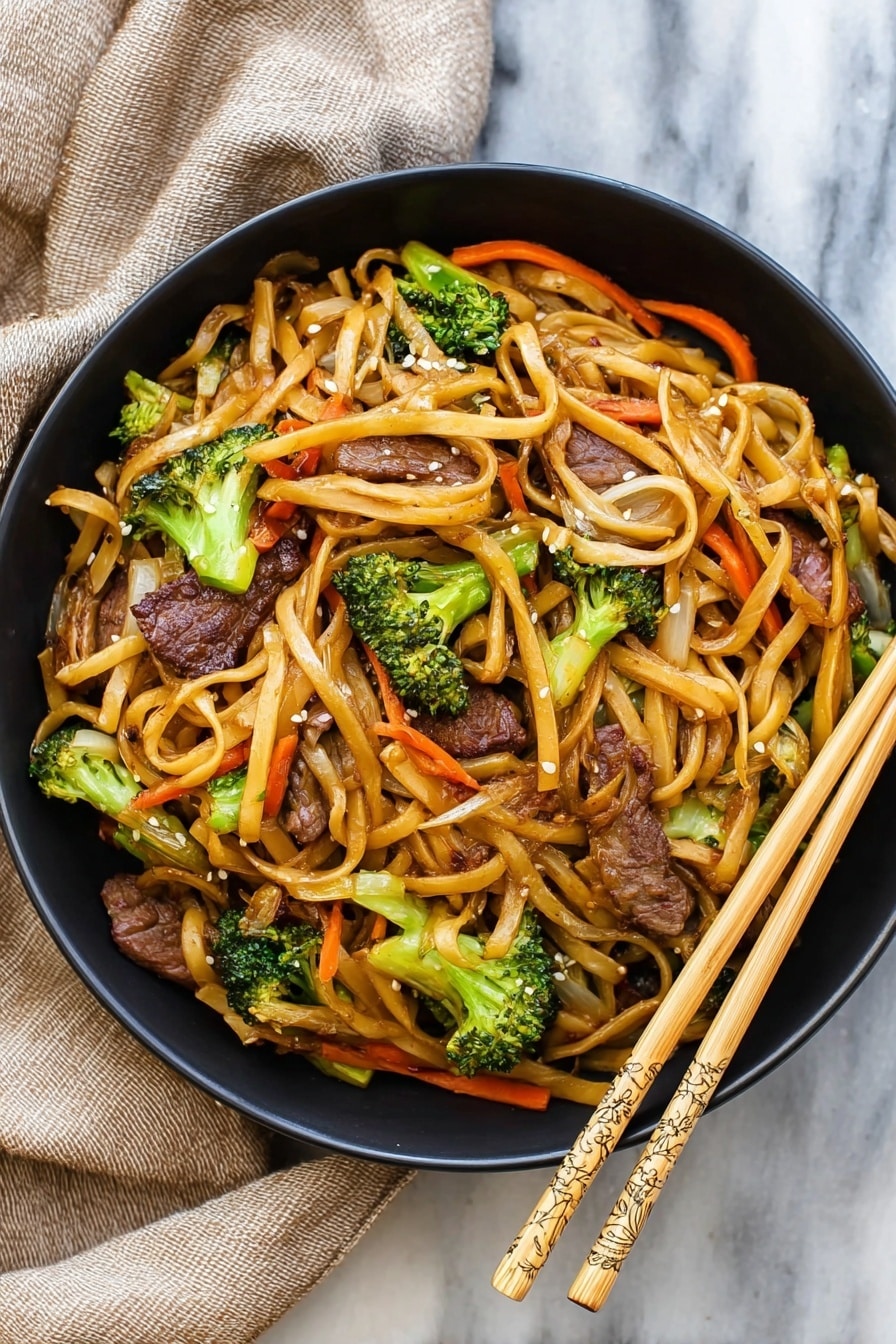 Homemade Beef Lo Mein Recipe 5 A black bowl filled with a stir-fry dish showing three main layers: at the bottom, light brown thin noodles tangled all over; in the middle, small bright green broccoli florets scattered evenly; on top, dark brown slices of beef mixed with bright orange thin carrot strips and some translucent onion pieces, all coated in a light glossy sauce with some white sesame seeds sprinkled throughout. The bowl sits on a white marbled surface with beige fabric and a pair of wooden chopsticks beside it. photo taken with an iphone --ar 4:5 --v 7