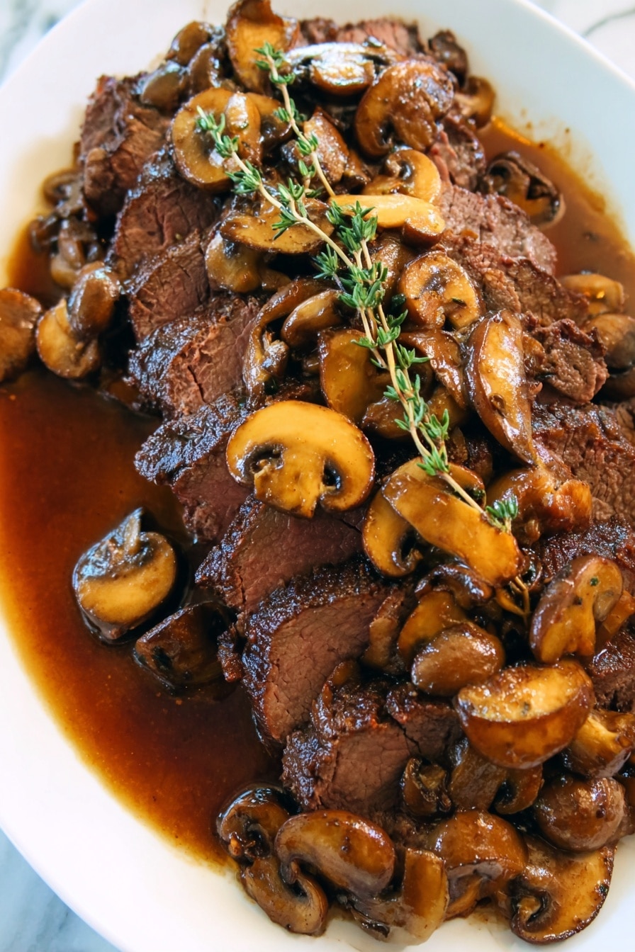 The image shows a white plate with several slices of cooked beef forming the bottom layer, with a slightly dark brown and juicy texture. On top, there is a thick layer of cooked mushroom slices glistening with a brown sauce, which appears rich and glossy, spreading around the beef slices as well. Fresh green thyme sprigs are placed on top, adding a fresh and vibrant contrast to the brown tones. The white marbled surface beneath the plate adds a clean and elegant background. Photo taken with an iphone --ar 4:5 --v 7