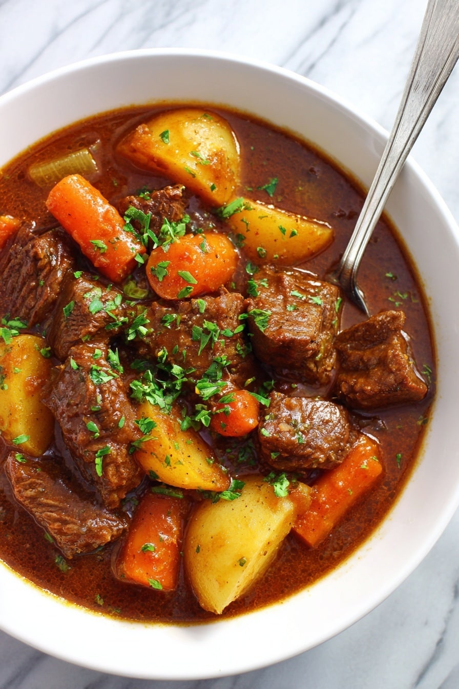 Slow Cooker Beef Stew Recipe 6 The image shows a white bowl filled with a stew made of thick chunks of brown meat, large pieces of golden yellow potatoes, bright orange carrot slices, and small pieces of light green celery, all in a rich brown sauce. The stew is topped with small bits of fresh green herbs, sprinkled evenly over the top. A silver spoon rests inside the bowl on the right side. The bowl sits on a white marbled surface that adds a clean and bright background to the dish. photo taken with an iphone --ar 2:3 --v 7 - Slow Cooker Beef Stew, easy beef stew, hearty slow cooker recipes, comforting beef stew, tender beef stew recipe