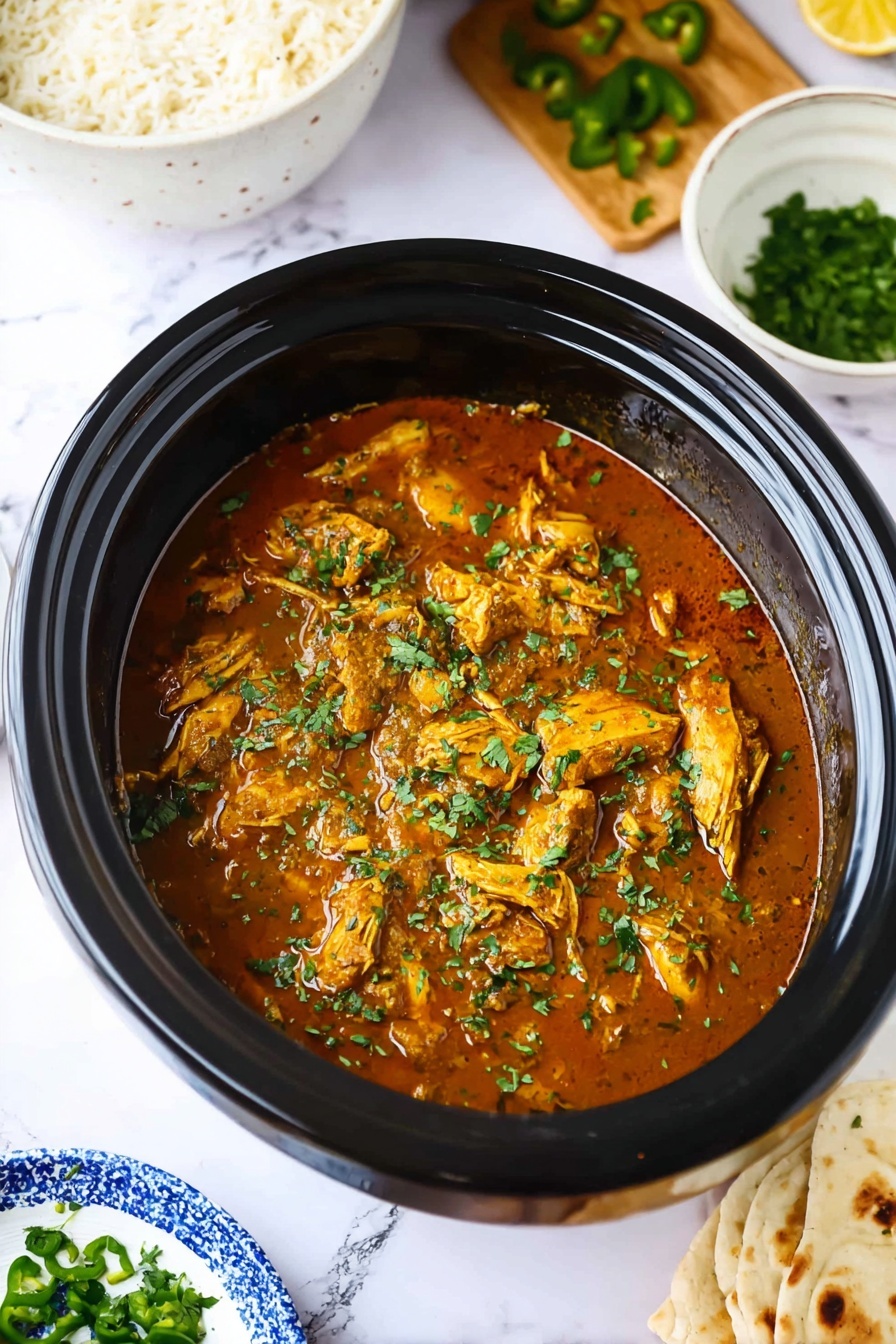 Easy Slow Cooker Chicken Curry Recipe 8 A close-up image of a black slow cooker filled with brown chicken curry topped with chopped green herbs, showing pieces of chicken submerged in a thick sauce. Surrounding it, on a white marbled surface, there is a white bowl with white rice on the top left, a wooden board with chopped green peppers on the top right, a small white bowl with chopped herbs on the bottom left, and a blue and white plate with flatbread on the bottom right. The scene is bright and fresh, highlighting the colors and textures of the curry and sides. photo taken with an iphone --ar 2:3 --v 7 - Easy Slow Cooker Chicken Curry, chicken curry in slow cooker, simple chicken curry recipe, beginner-friendly curry dish, hearty slow cooker dinner