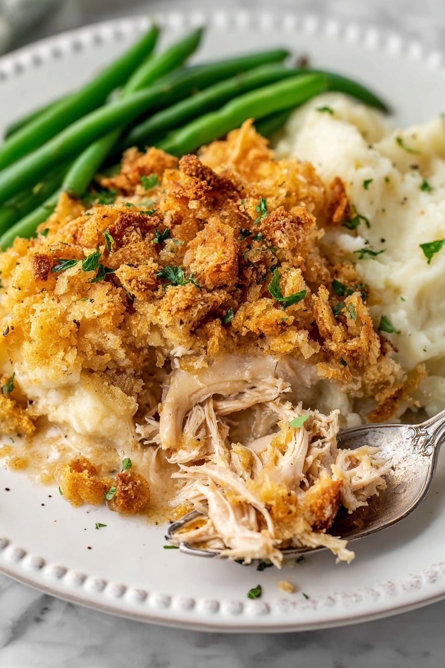 Crockpot Chicken and Stuffing Recipe 8 The dish shows a white plate with three main parts: on the top left, there are several long green beans fresh and bright; next to the green beans, on the right, is a portion of a baked casserole with a golden-brown crunchy topping sprinkled with small green herbs, covering shredded white meat mixed with a creamy sauce. On the left half of the plate, smooth mashed potatoes spread in a soft white creamy color with some black pepper specks. A silver fork is partially inserted under the casserole, breaking it open from the side. The plate is placed on a white marbled surface. photo taken with an iphone --ar 2:3 --v 7 - Crockpot Chicken and Stuffing, easy slow cooker dinner, comforting chicken casserole, family-friendly slow cooker meal, simple chicken and stuffing recipe
