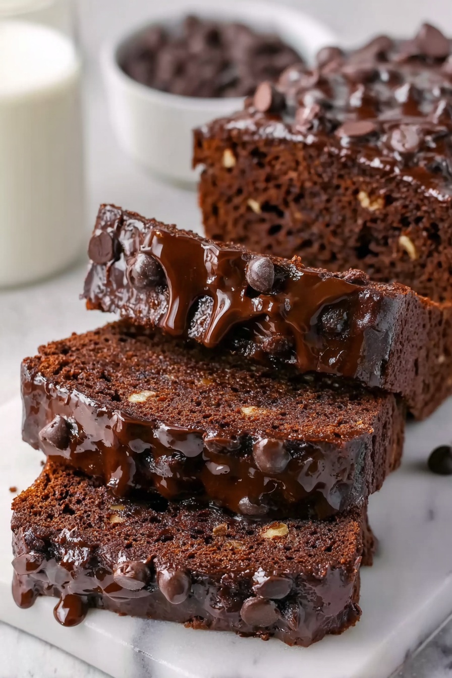 Healthy Chocolate Banana Bread Recipe 8 The image shows a close-up of three slices of rich chocolate cake stacked on a white marbled surface. The top layer is thick and glossy, covered with melted chocolate dripping over the edges and scattered with chocolate chips. The middle and bottom layers have a moist, dark brown texture filled with small pieces of nuts. The background includes a white bowl filled with chocolate chips and a glass of milk partly shown. photo taken with an iphone --ar 2:3 --v 7 - Healthy Chocolate Banana Bread, wholesome banana bread with cocoa, nutritious chocolate banana loaf, guilt-free banana bread recipe, healthy baking with bananas