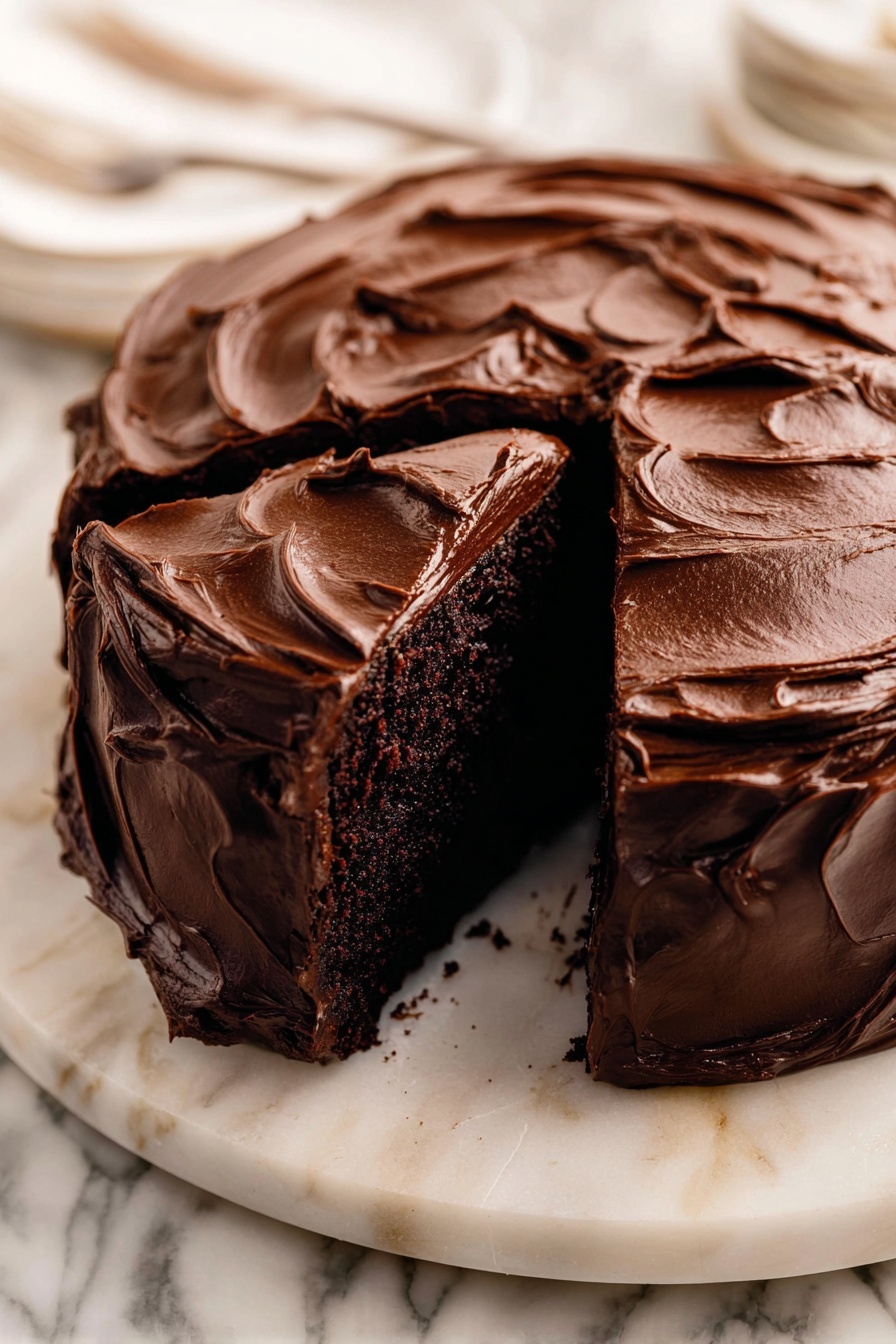 Decadent Chocolate Cake with Fudge Frosting Recipe 6 A round chocolate cake with one thick slice removed sits on a white marble platter. The cake is covered fully in rich, glossy chocolate frosting that is thickly spread with swirling, textured waves all over the top and sides. The inside of the cake layer shows a dark, dense chocolate crumb. The white marble platter contrasts with the deep brown of the cake, and the background has a white marbled texture. Photo taken with an iphone --ar 2:3 --v 7 - Decadent Chocolate Cake with Fudge Frosting, rich chocolate cake recipe, moist chocolate cake, homemade fudge frosting, dessert for special occasions