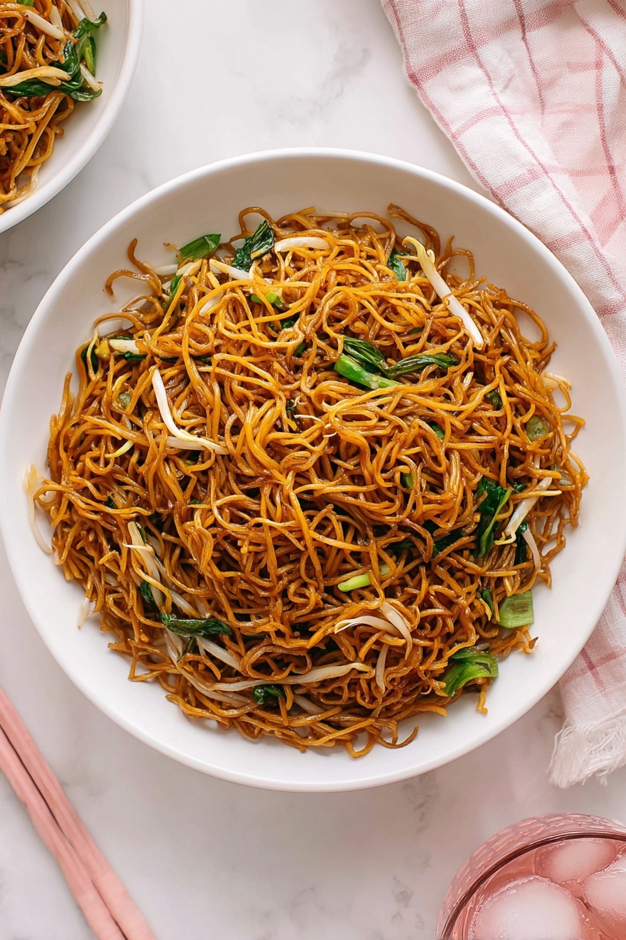 Cantonese Chow Mein Stir Fry Recipe 6 A white bowl is filled with a single layer of thin, brown stir-fried noodles mixed with small pieces of green vegetables and light, translucent bean sprouts, giving a mix of green, brown, and white colors. The noodles are twisted and tangled, sitting neatly in the bowl placed on a white marbled surface. Pink chopsticks lie beside the bowl, and a pale pink checkered cloth is near the bottom edge of the image. There is a hint of a pink glass with ice on the left side and a white pot with a green succulent plant on the right. Photo taken with an iphone --ar 2:3 --v 7 - Cantonese Chow Mein Stir Fry, Chinese noodle stir-fry recipe, crispy chow mein noodles, easy Cantonese stir-fry, takeout-style noodle dish