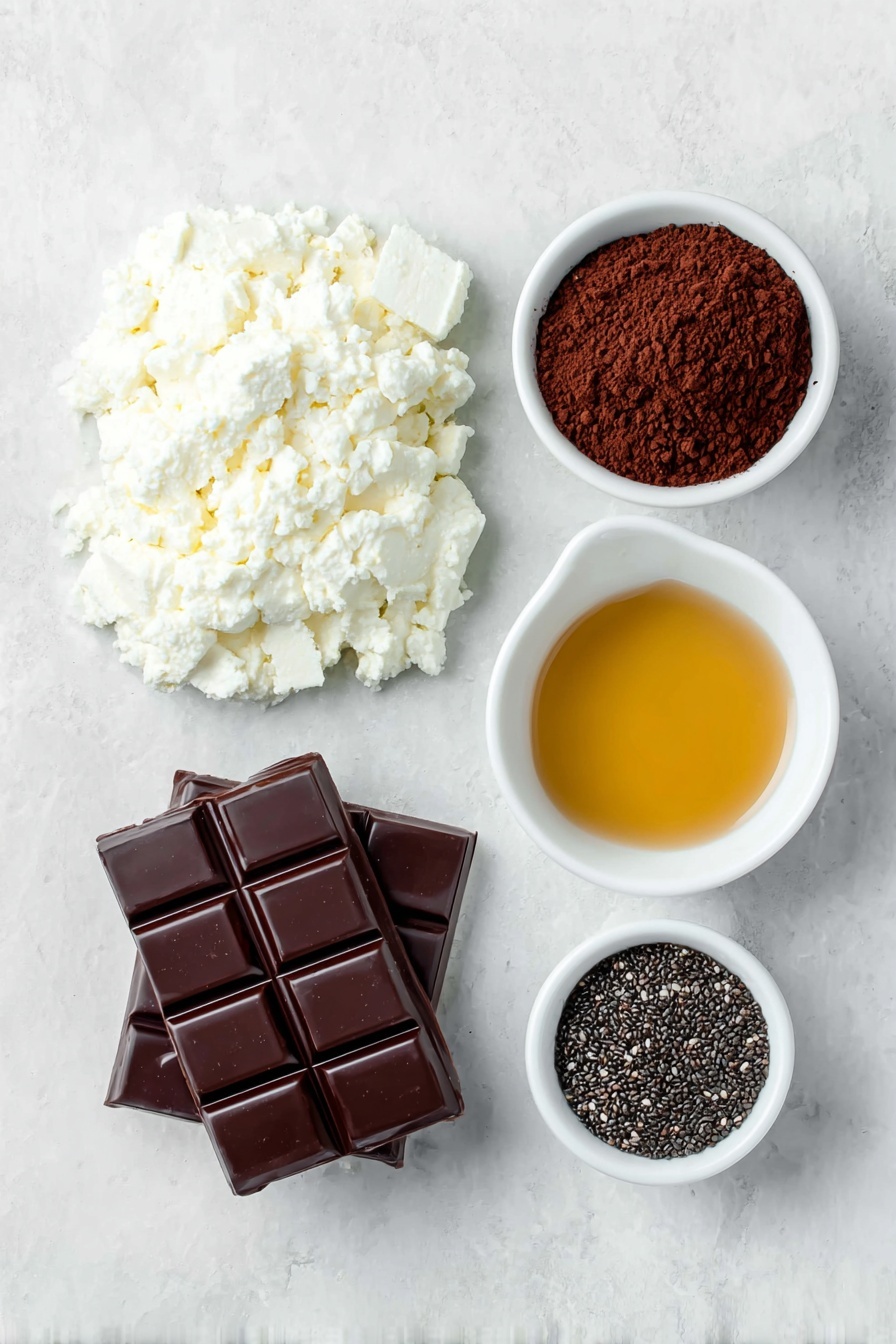 Cottage Cheese Chocolate Mousse Recipe 7 Flat lay of a small mound of fresh, white cottage cheese, a neat heap of rich dark brown cocoa powder, a small white ceramic bowl with smooth, glossy melted dark chocolate, a small white bowl filled with golden honey syrup, and a small white bowl holding shiny black chia seeds, all arranged symmetrically and balanced, placed on a clean white marble surface, soft natural light, photo taken with an iPhone, professional food photography style, fresh ingredients, white ceramic bowls, no bottles, no duplicates, no utensils, no packaging --ar 2:3 --v 7 --p m7354615311229779997 - Cottage Cheese Chocolate Mousse, healthy chocolate mousse, protein-packed dessert, easy chocolate mousse recipe, whipped cottage cheese dessert