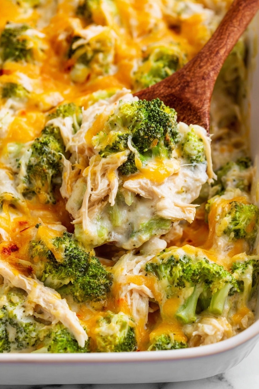 Chicken Bacon Ranch Casserole Recipe 6 This image shows a baked casserole in a white dish on a white marbled surface. The casserole has three main layers: chunks of white shredded chicken at the base, bright green broccoli florets spread evenly on top, and a melted mixture of yellow and white shredded cheeses covering the whole dish. The cheese has a slightly toasted texture in some spots, adding a bit of golden brown color. There is a wooden spoon scooping a portion from the casserole, showing a mix of chicken, broccoli, and cheese. The lighting is bright, highlighting the creamy and textured look of the food. photo taken with an iphone --ar 2:3 --v 7 - Chicken Bacon Ranch Casserole, easy chicken bake with bacon and ranch, cheesy chicken casserole recipe, quick weeknight dinner ideas, crowd-pleasing chicken bake