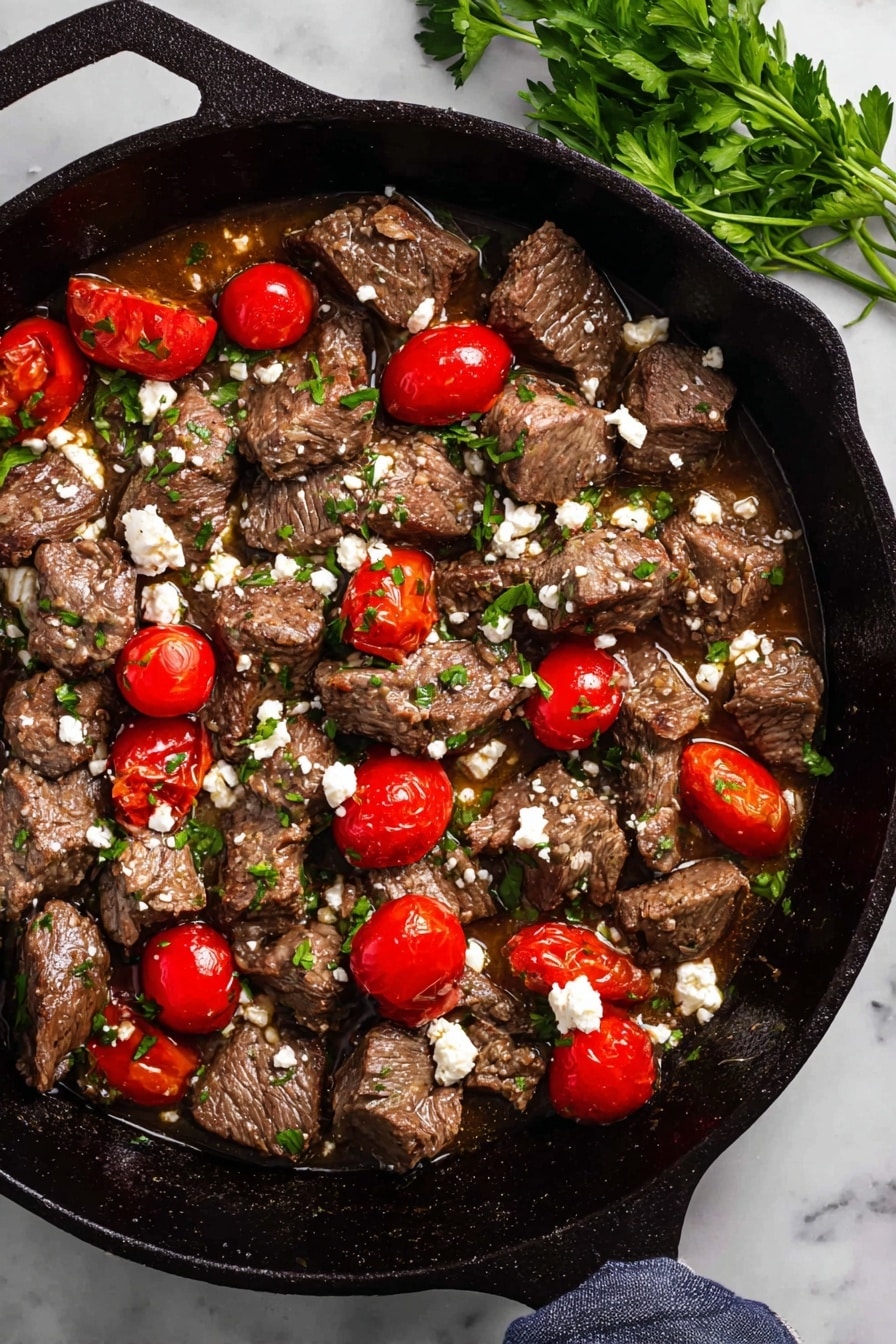 Mediterranean Steak Bites with Yogurt Sauce Recipe 6 The image shows a cast iron pan filled with medium brown cooked meat chunks scattered evenly across the pan. Among the meat chunks, several bright red cherry tomatoes, some whole and some sliced in half, add vibrant color. Small green parsley leaves are sprinkled throughout, alongside crumbled white cheese dots that create contrast against the meat. The pan sits on a white marbled surface with a small green parsley sprig placed nearby. The overall texture looks juicy with a bit of sauce pooling at the bottom. Photo taken with an iphone --ar 2:3 --v 7 - Mediterranean Steak Bites with Yogurt Sauce, Greek steak bites recipe, juicy steak appetizer with yogurt, quick Mediterranean steak snack, flavorful steak bites with sauce